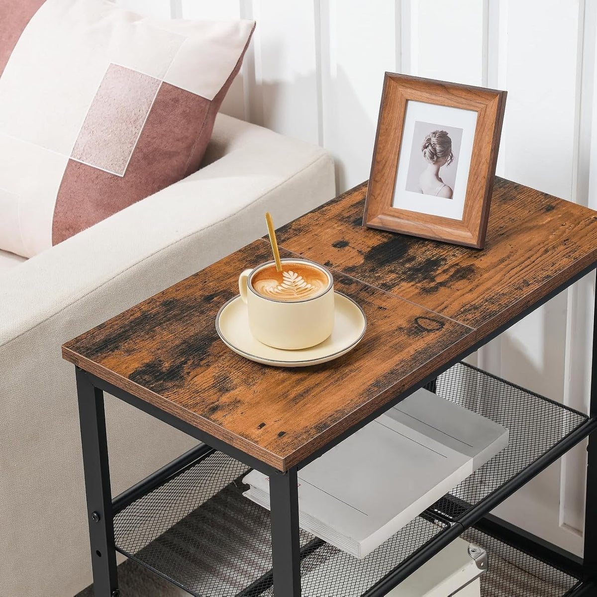 Side table top styled with coffee cup beside a sofa, angled view